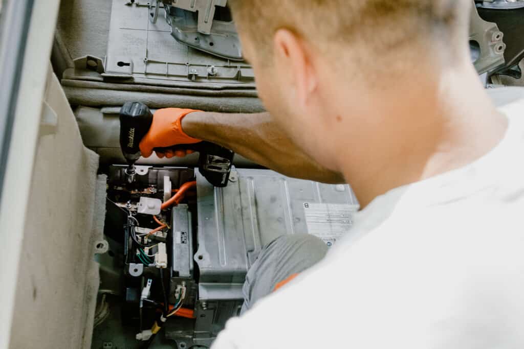 Technician replacing a Toyota hybrid battery in a car